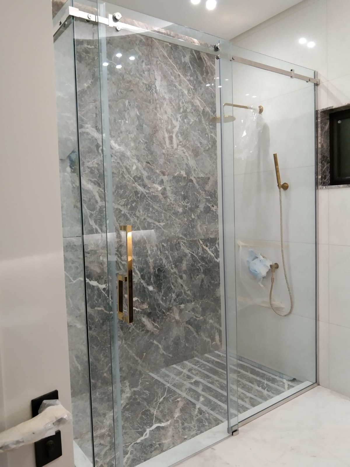 Frameless shower enclosure